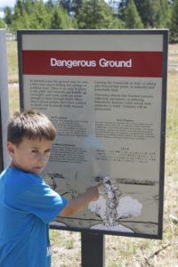 B is pointing to the hat being blown off as the kid steps on a hot spring..
